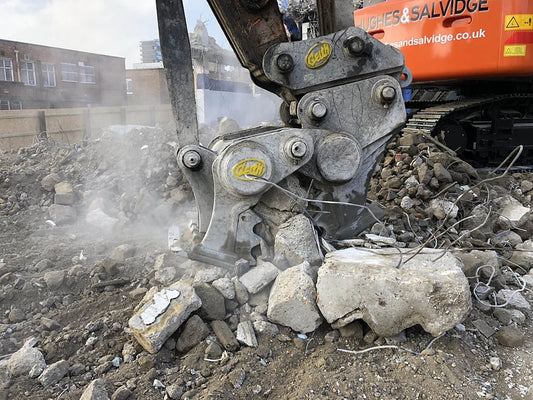Geith concrete crusher working amidst rubble in urban construction site with a machinery banner in the background.